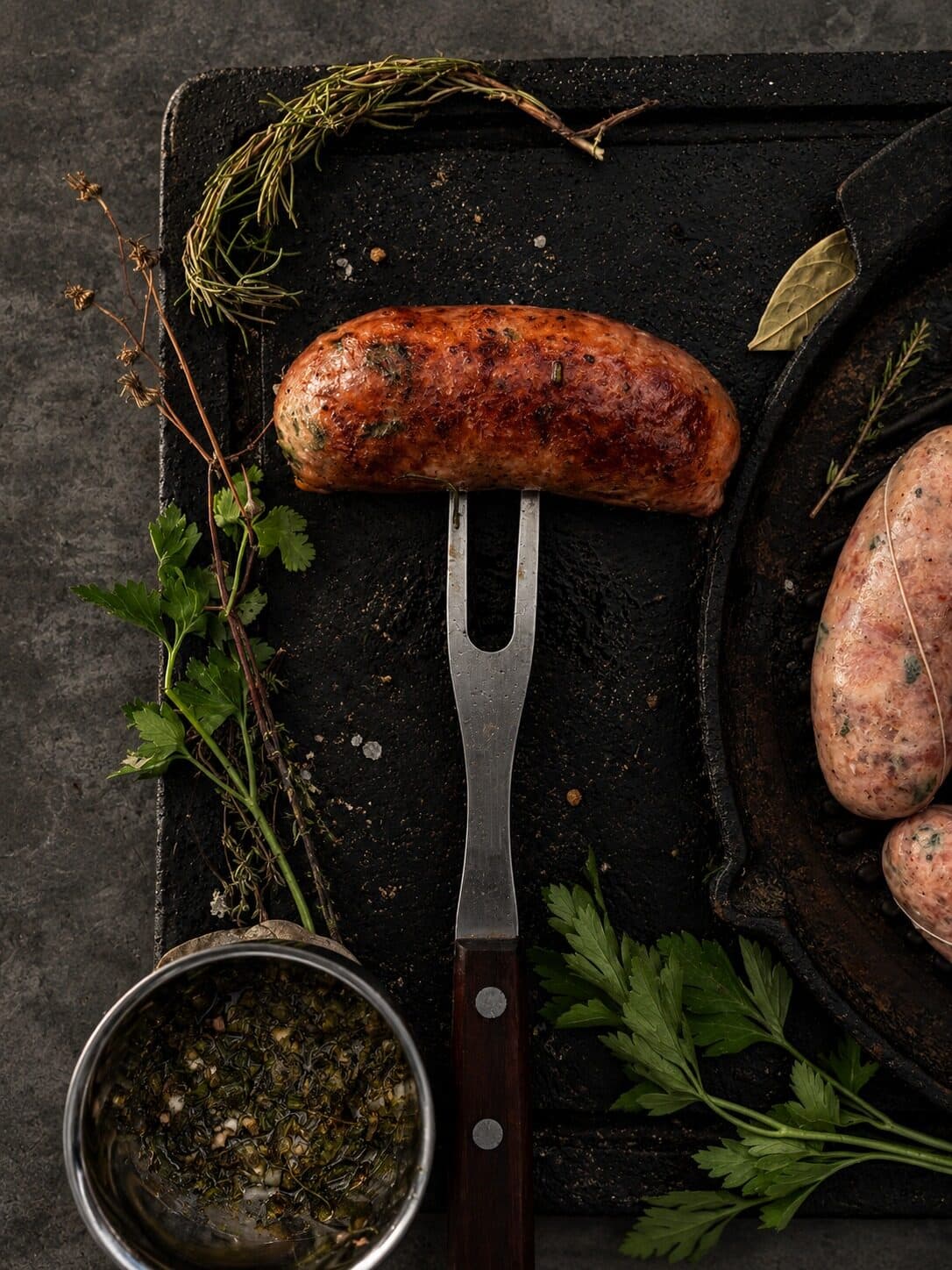 Chorizo paisa asado en un tenedor de trinchar